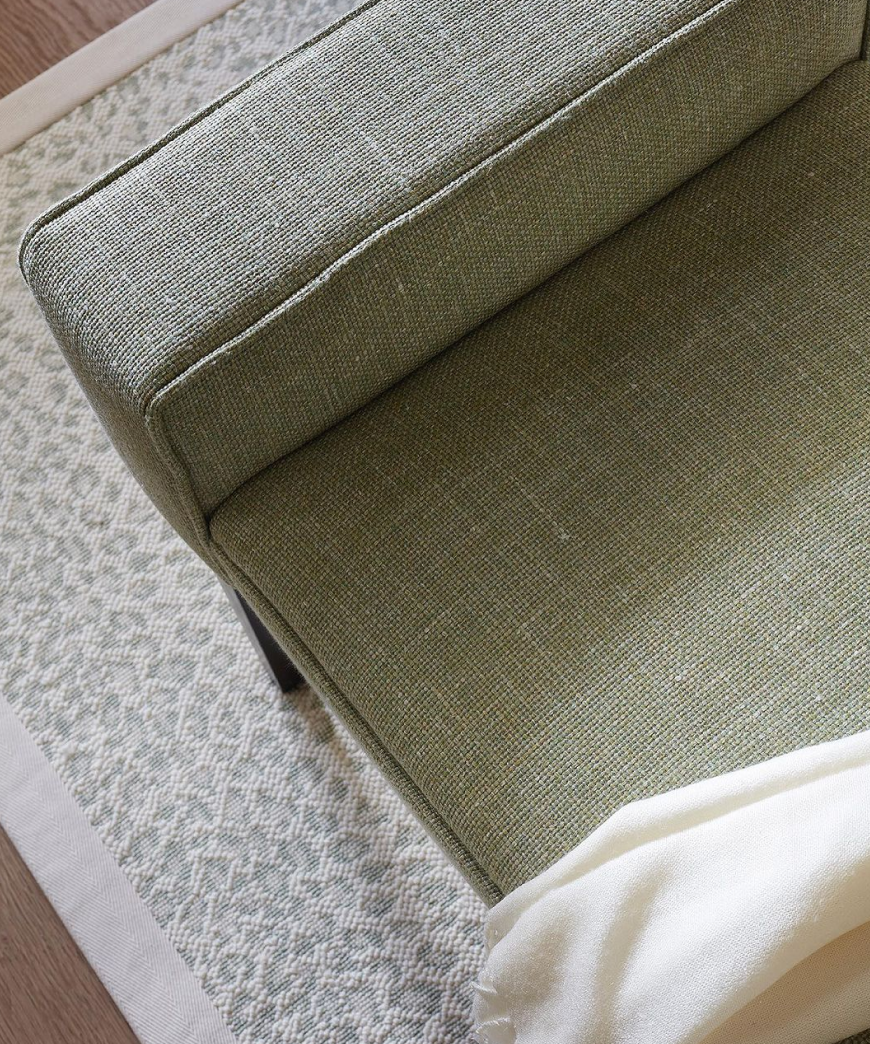 Grey armchair on a patterned rug.