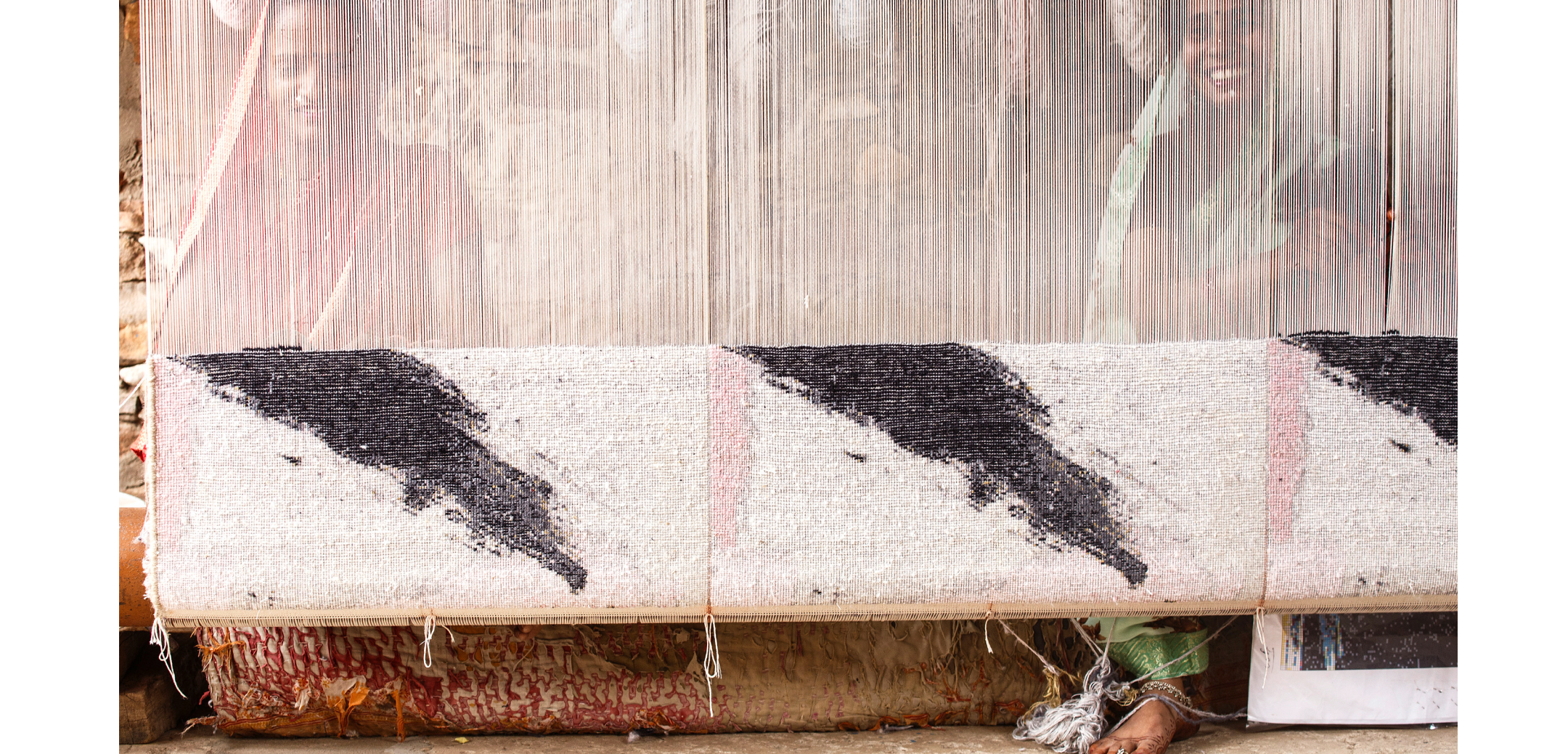A large rug being woven